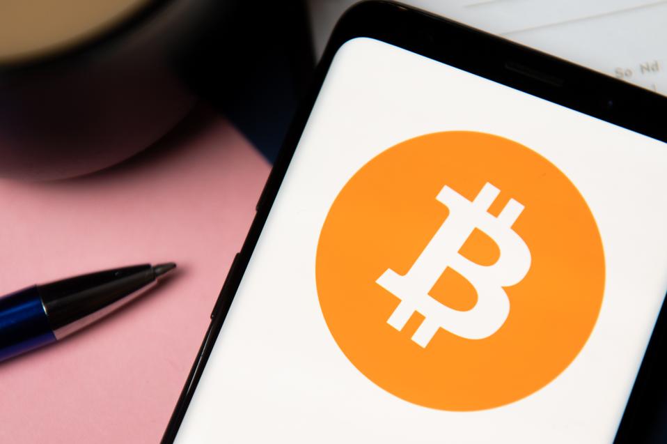 In this photo illustration a Bitcoin logo displayed on a...