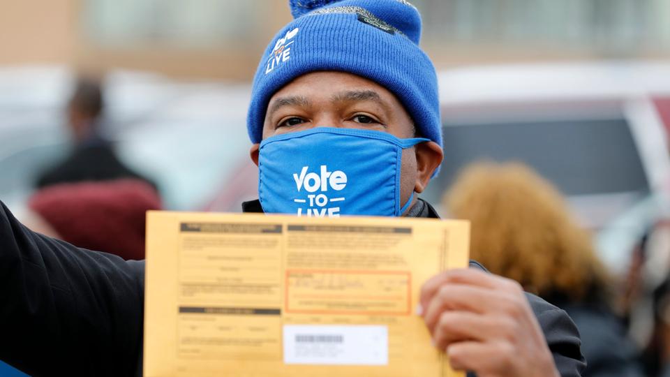 Biden rally supporter Detroit holds mail-in ballot