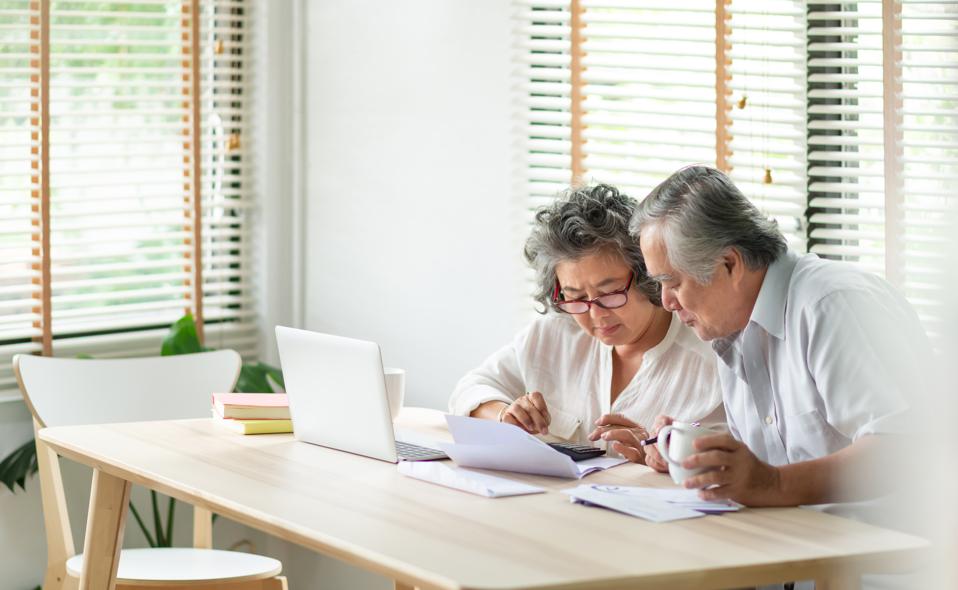 Older couple looking over documents Older couple looking over documents
