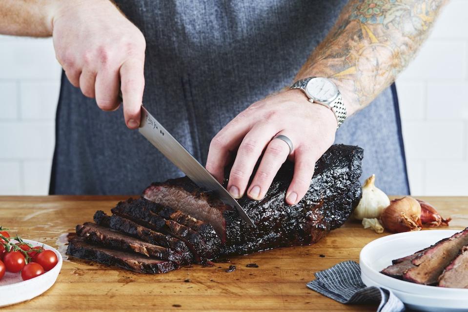 man cutting brisket