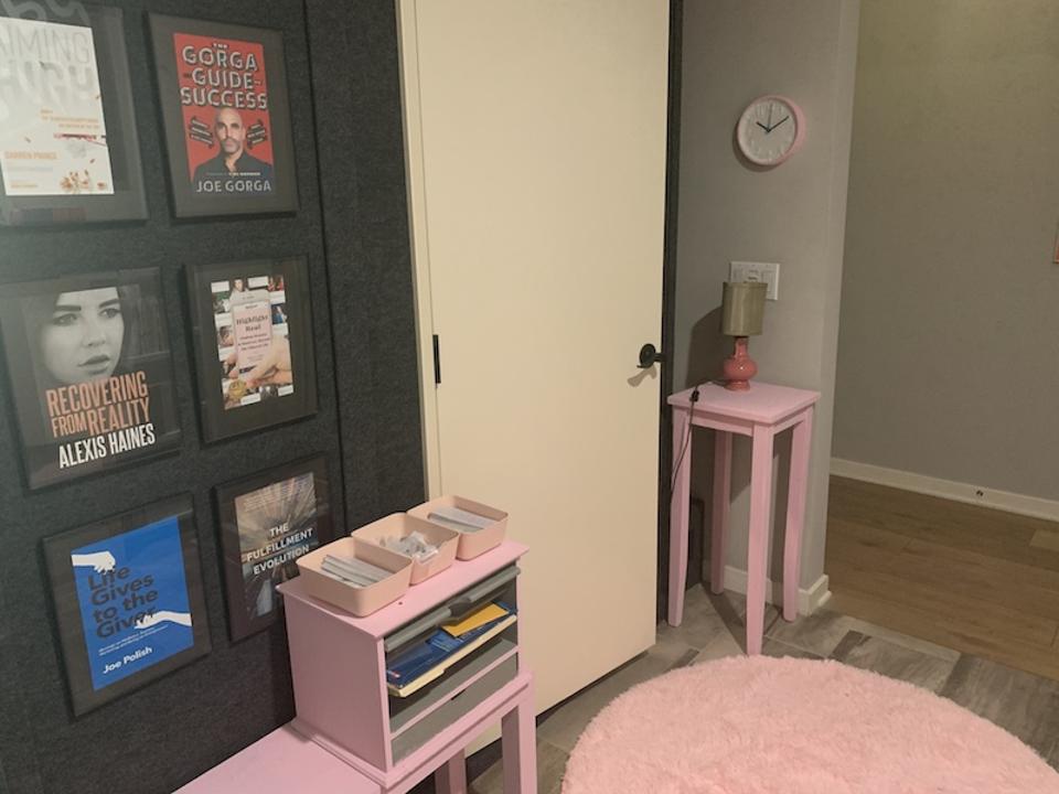 pink table, pink rug, pink shelves and book covers on the wall