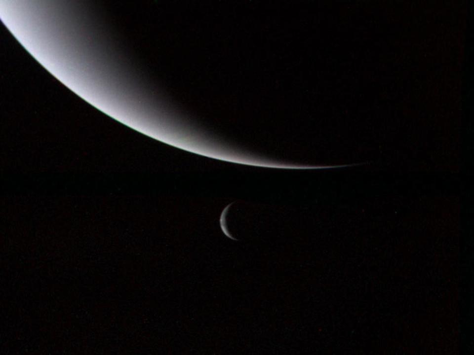 The illuminated crescents of Neptune (foreground) & its largest moon Triton (background).