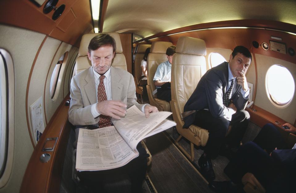 businessmen and women sitting in the passenger cabin of a Dassault Falcon 20