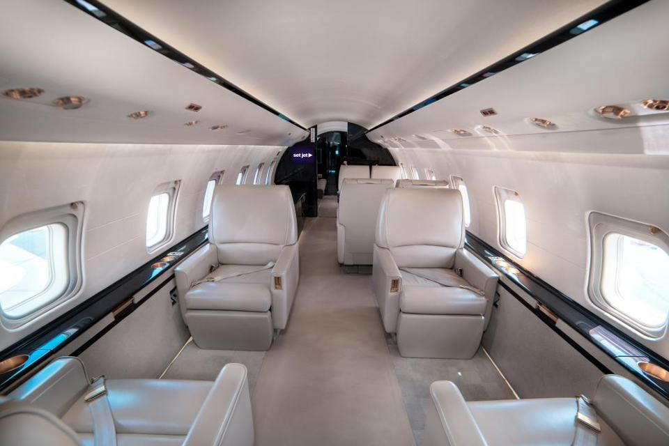 El interior de un jet privado con amplios asientos.