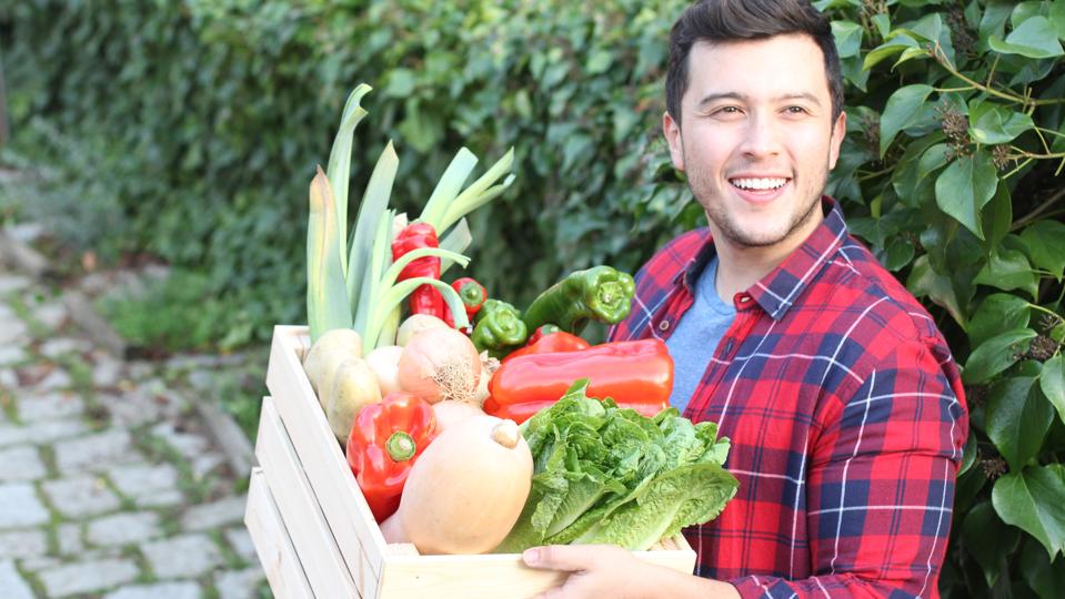 Cute guy holding basket with natural food