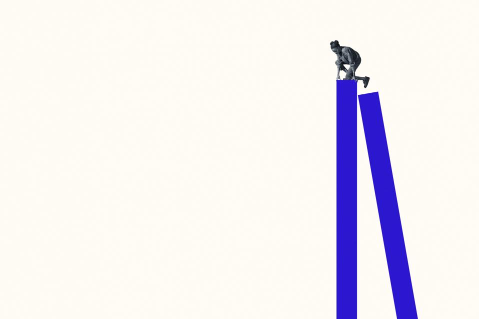 Young woman climbing on tall blue bar graph