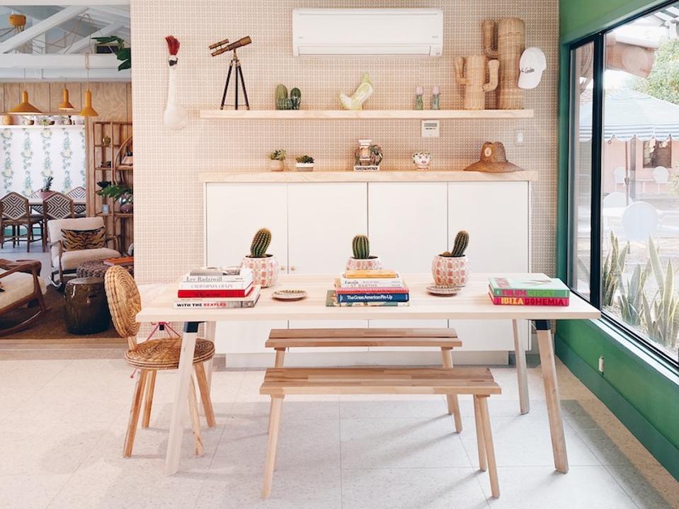 Wood table with benches, a chair and coffee table books.