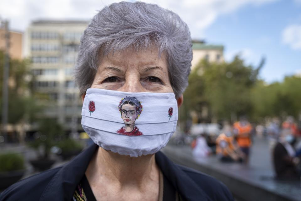 A protester looks on while wearing a face mask as a...