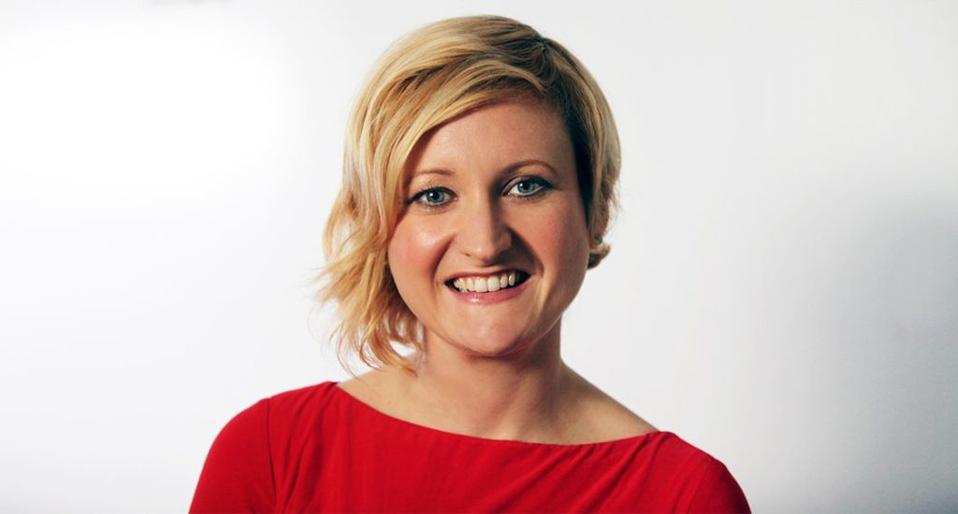 Headshot of Emily May, wearing a red shirt