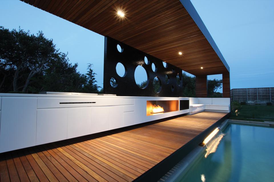 The fireplace is built into the outdoor kitchen cabinetry. 