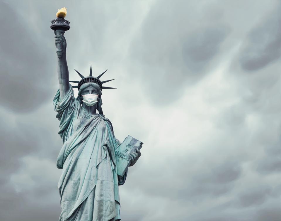 Stock photo of the New York's Statue of Liberty with a mask caused by the coronavirus and copy space