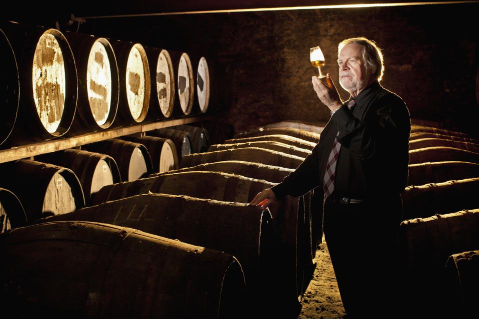 Worker testing whisky in distillery
