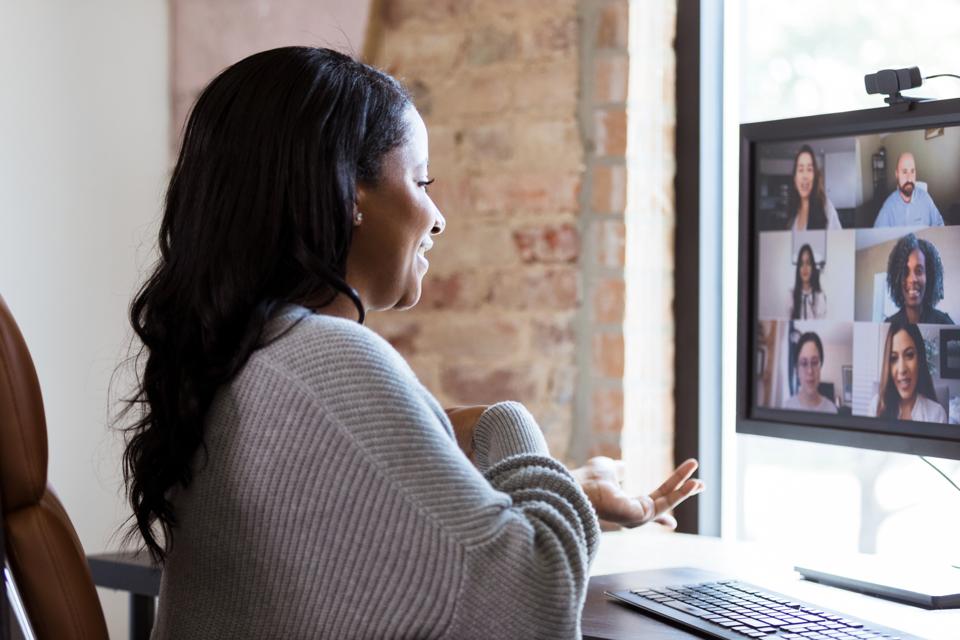 Cheerful woman video chats with colleagues