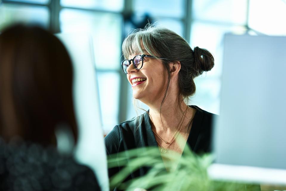 Candid portrait of mature businesswoman in glasses laughing