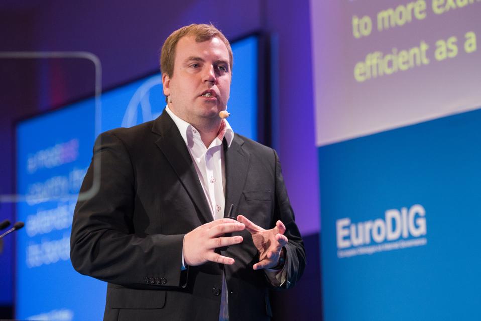 White man on stage speaking