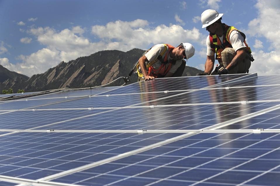 Chris Kouns, left and Dave Cook, right, Solar Panel installers with Bella Energy, finish installing panels on the roof top of 1535 Spruce Street in Boulder.The sudden suspension and lower incentive rates of Xcel Energy's rebate program has drastically imp