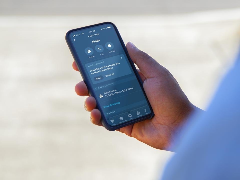 Photo f a person holding their smartphone with the Care Hub screen showing mom's activity