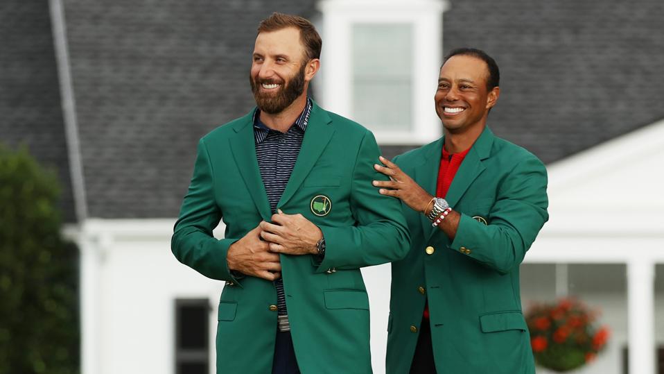 Dustin Johnson is awarded the Green Jacket by Masters champion Tiger Woods.