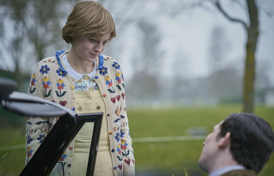 Emma Corrin wearing Diana's yellow dunagrees and patterned cardigan