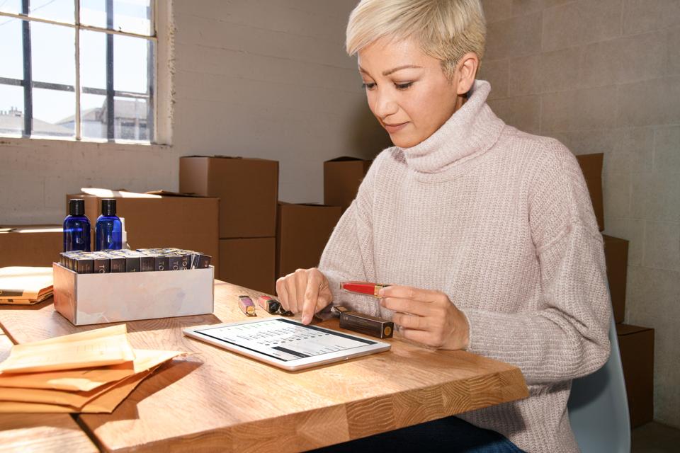 A cosmetics seller manages their inventory using the mobile app on their tablet.