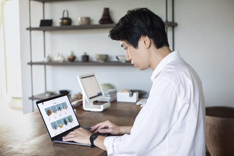 A business owner manages their online store from their laptop.