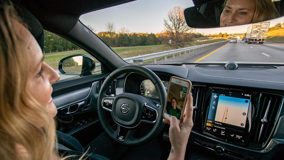 A distracted driver viewing a cell phone while driving.