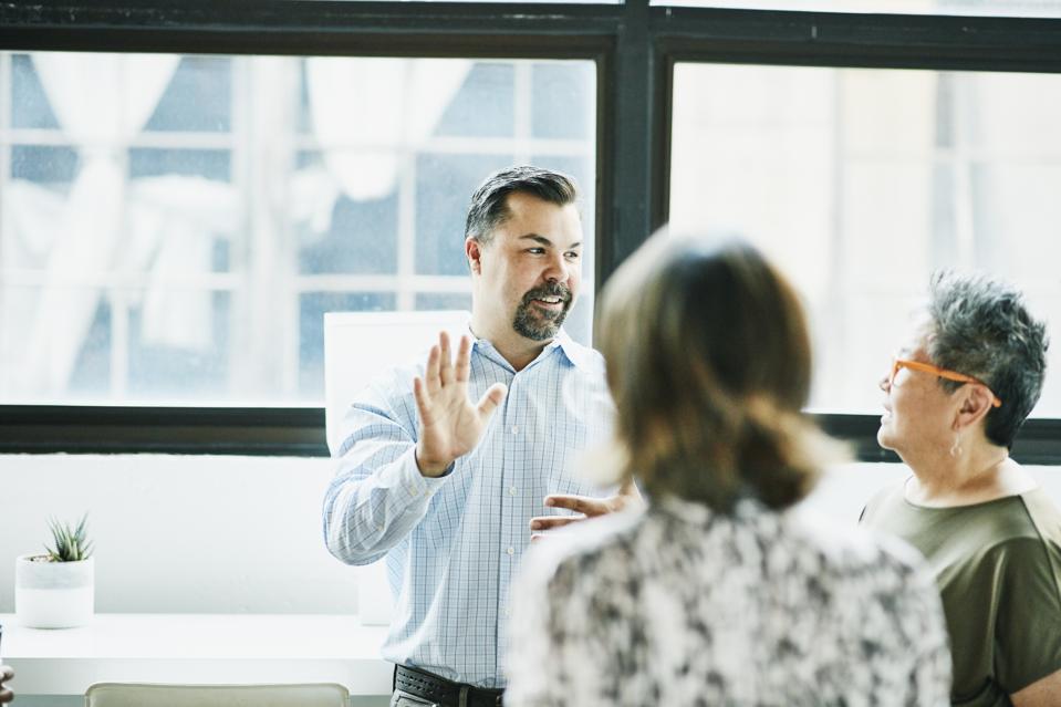 Businessman leading project discussion with colleagues during meeting in office