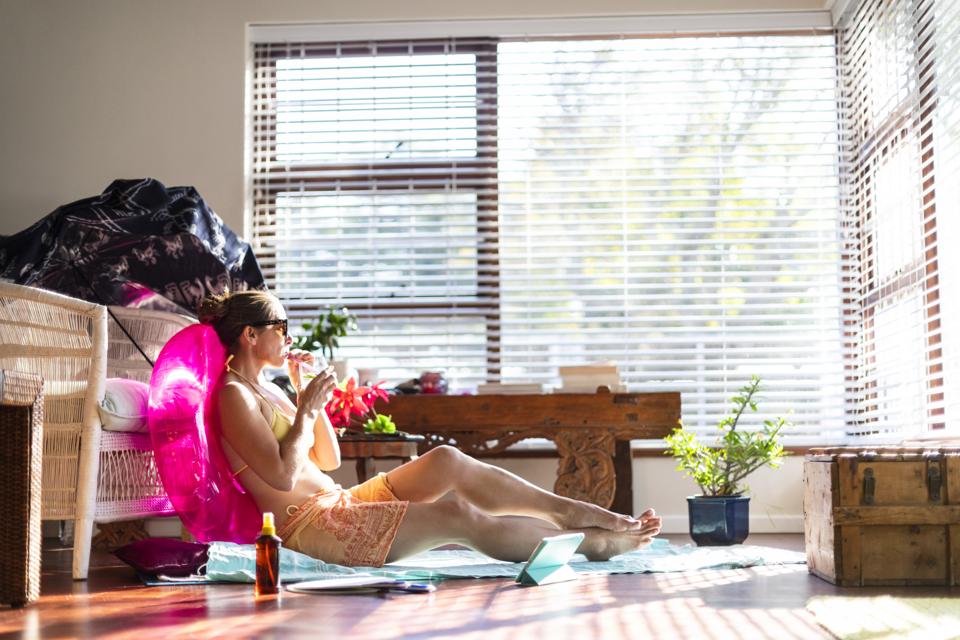Woman sipping cocktail enjoying summer at home during travel ban