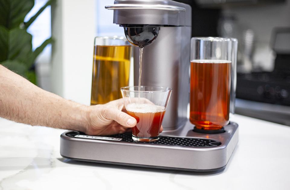 A machine pouring a cocktail into a glass.