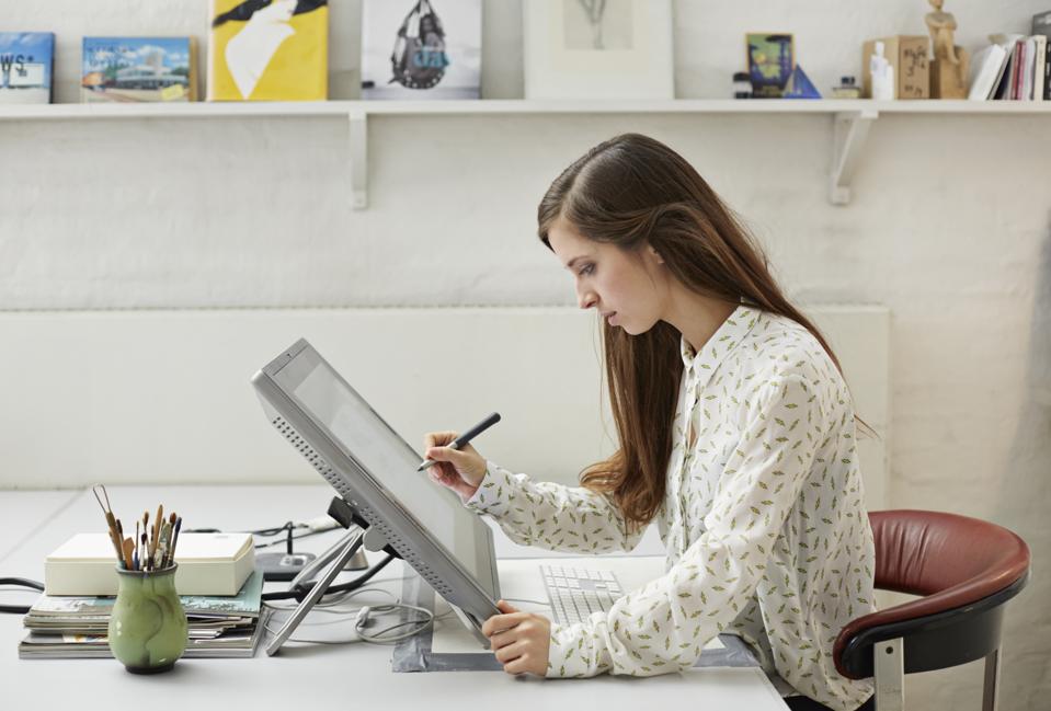 Young graphic designer working with pen on screen