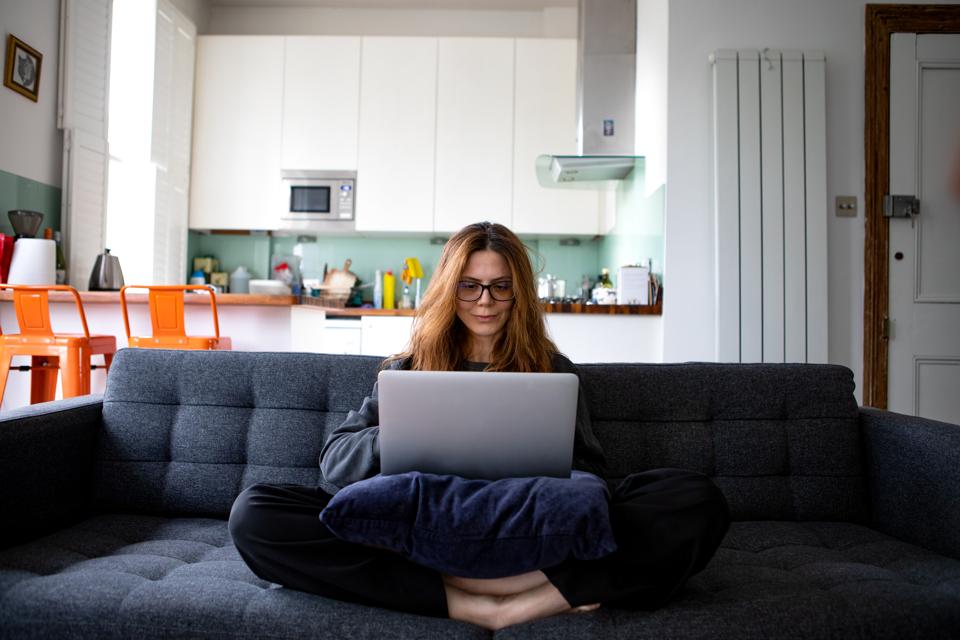 A woman using laptop, working from home.