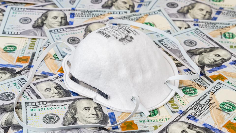 N95 respirator mask with 100 dollar bills. Concept of supply and demand, shortage and price gouging due to Covid-19 coronavirus worldwide pandemic
