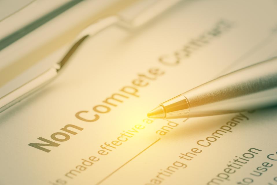 Legal form concept : Blue pen and a non compete contract on a clipboard. Noncompete contract is an agreement between employee and employer, not to enter into competition in subsequence business effort