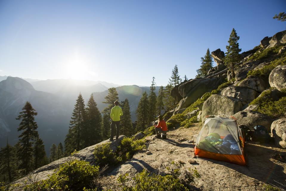 A couple watching sunrise while camping.