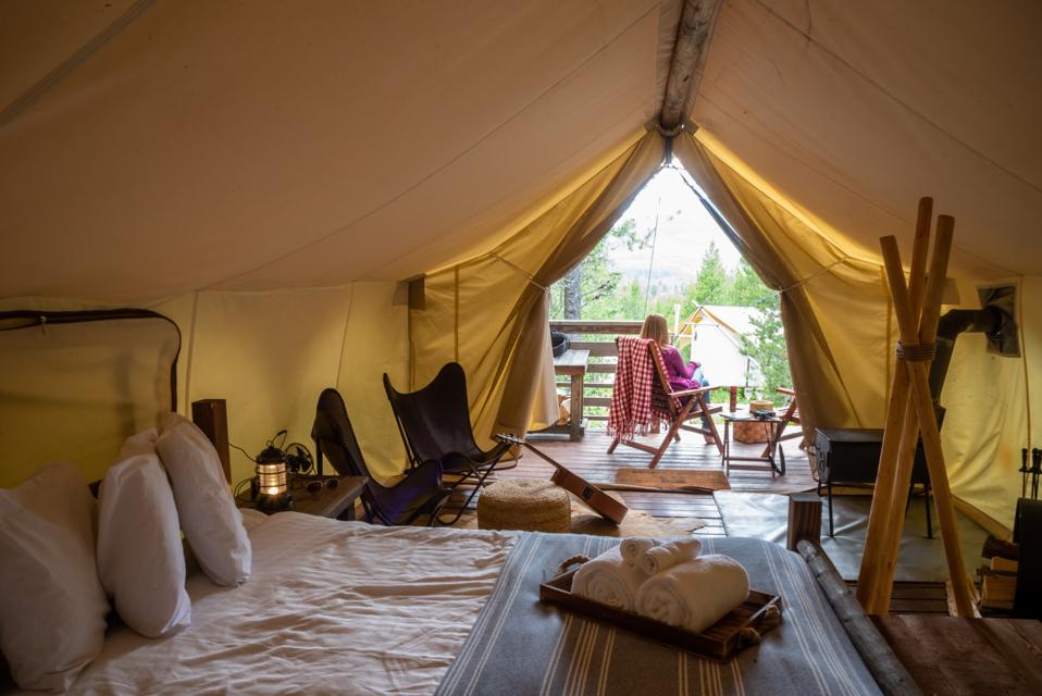 Woman sitting outside luxury tent on glamping trip in Glacier National Park