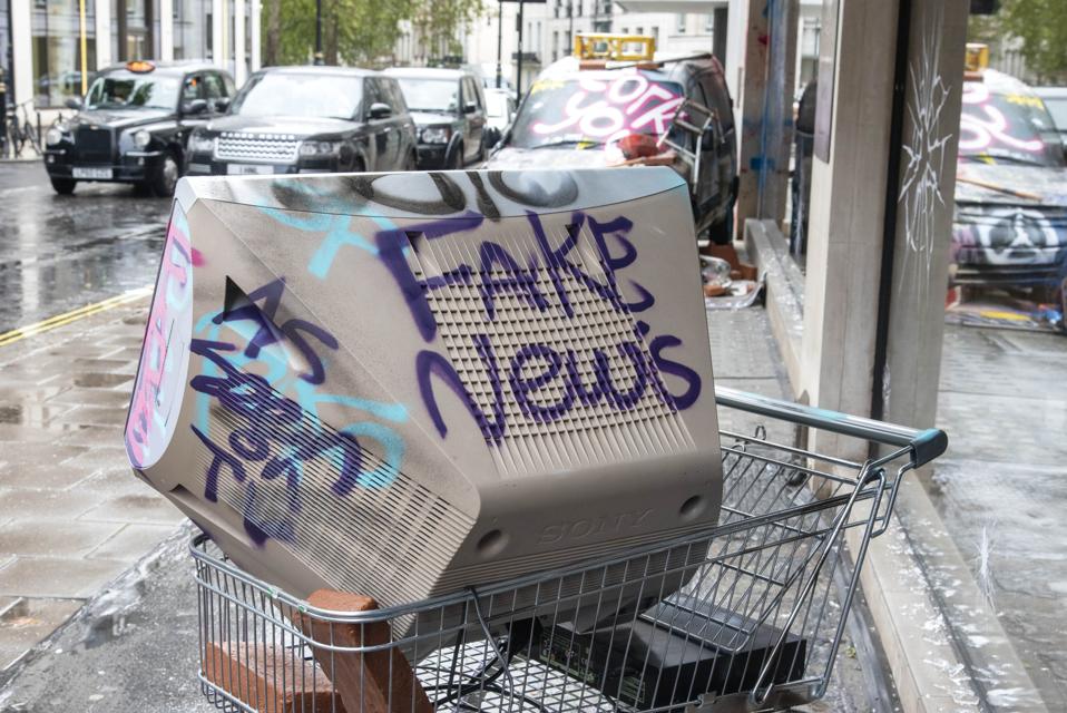 A television at a shopping trolley with the words Fake...