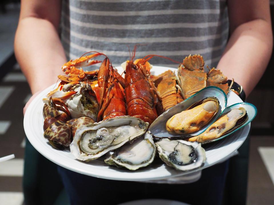 Plate of shellfish, including mussels, oysters, prawns, and shrimp.