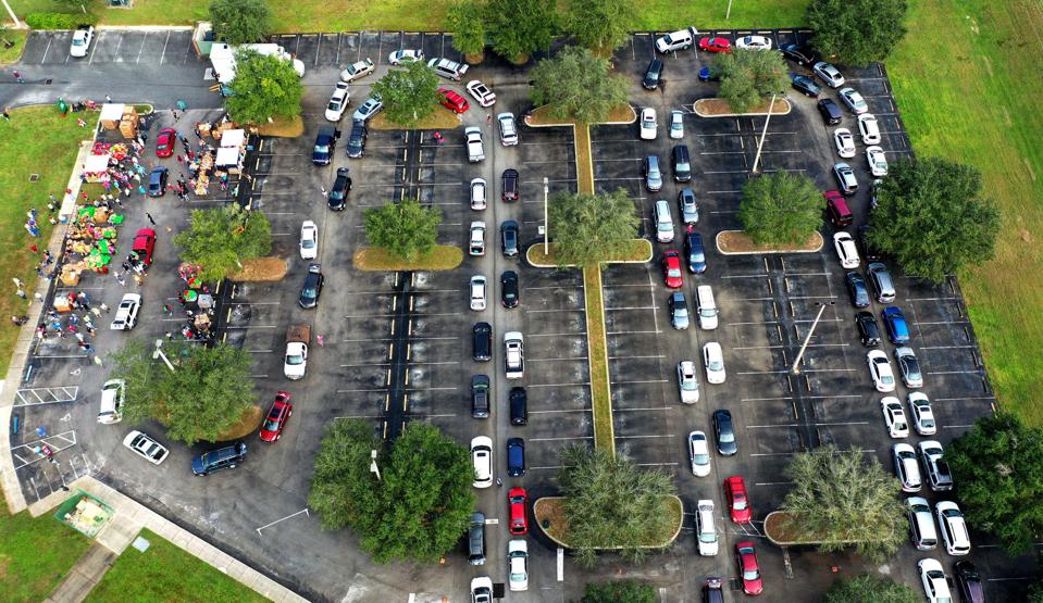 Residents line up in their cars at a food distribution site.