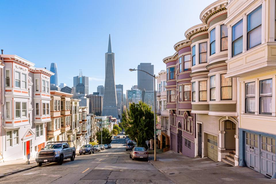 Street with residential district with skyscrapers of San Francisco financial district in the background, San Francisco, California, USA