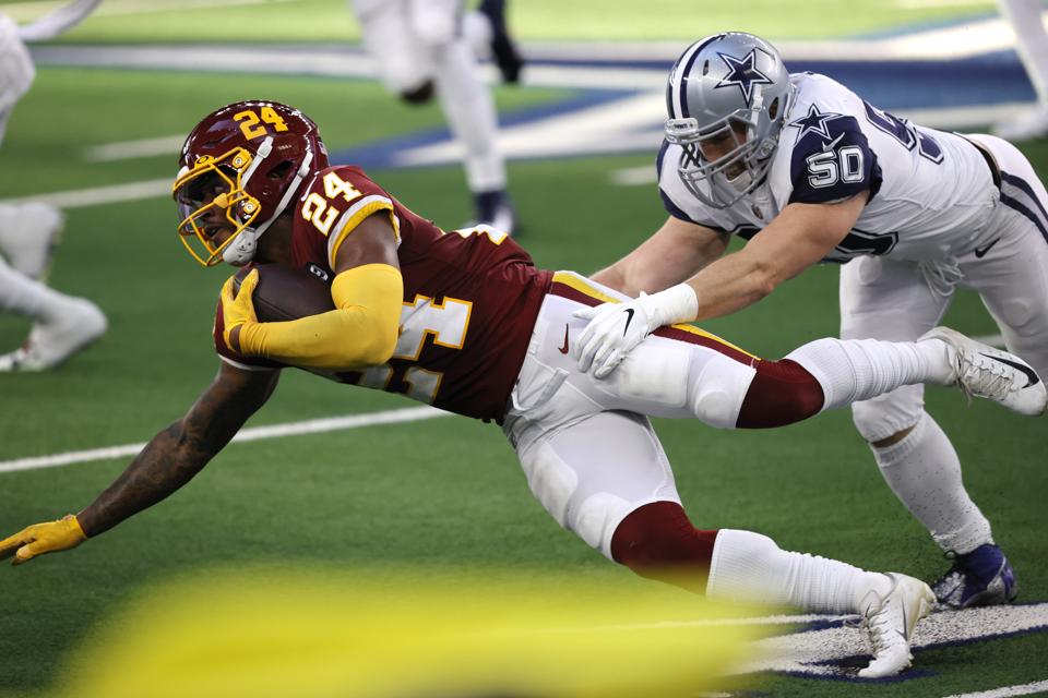 Antonio Gibson #24 of the Washington Football Team is brought down by Sean Lee #50 of the Dallas Cowboys during the second quarter of a game at AT&T Stadium on November 26, 2020 in Arlington, Texas. (Photo by Tom Pennington/Getty Images)