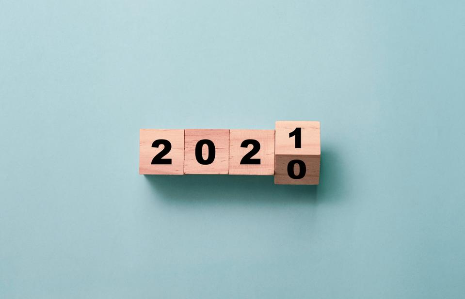 Four wooden blocks showing the year 2020 becoming the year 2021.