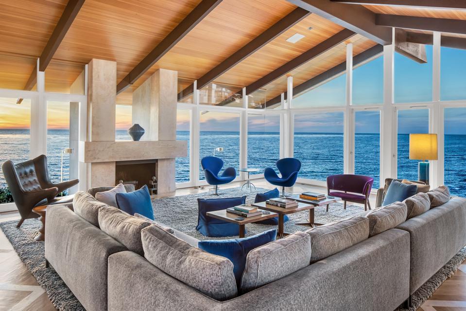 A walled-glass living room with an ocean view.