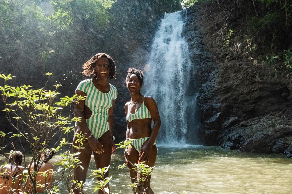 women smiling in front of waterfall