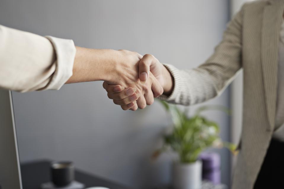 Female entrepreneurs shaking hands at workplace