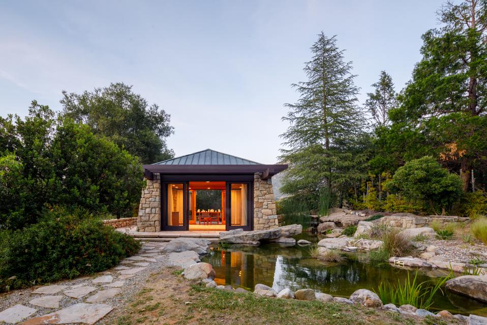 A meditation room set next to a pond.