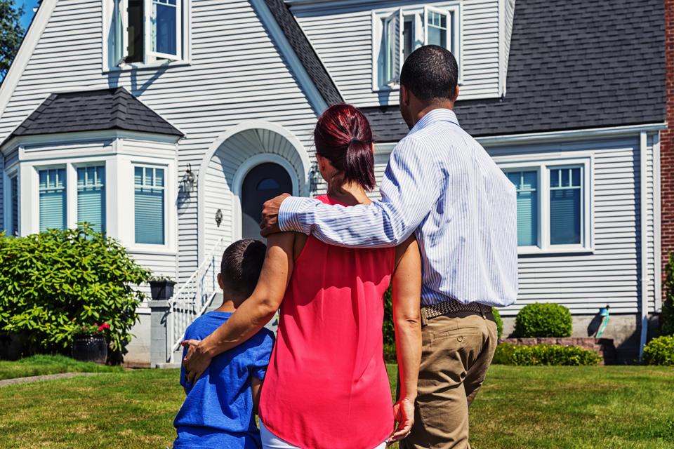 Happy Young Family Admiring Home