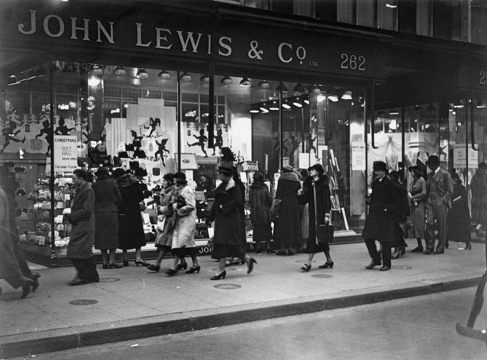 Passers-by outside John Lewis and Co's department store in Oxford Street, London, where there is a window display for Christmas gifts.