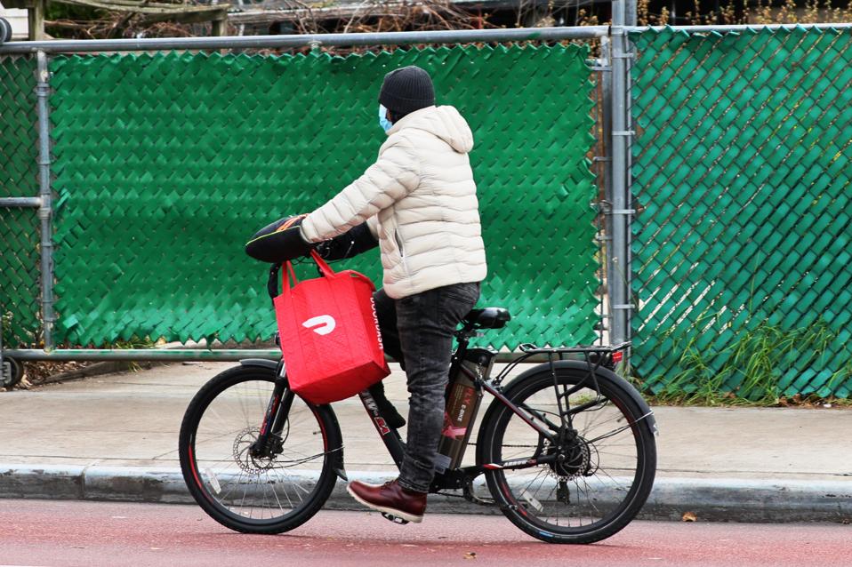 Un trabajador de entrega de DoorDash monta su bicicleta en Brooklyn en diciembre de 2020 mientras la empresa planea salir a bolsa.
