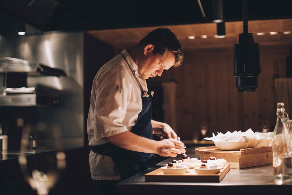 Austrian chef Max Natmessnig is putting the finishing touches on plates at his restaurant