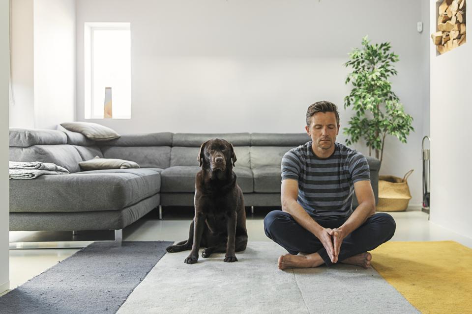 Man meditating with his pet dog